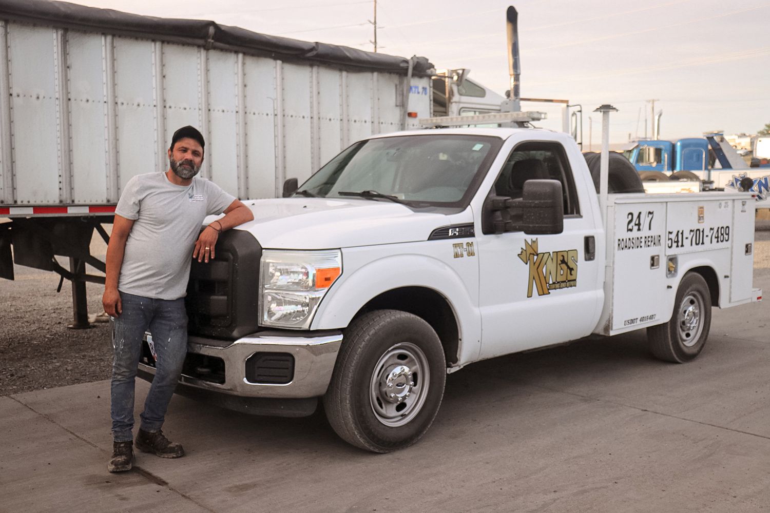 A man is standing next to a white truck.