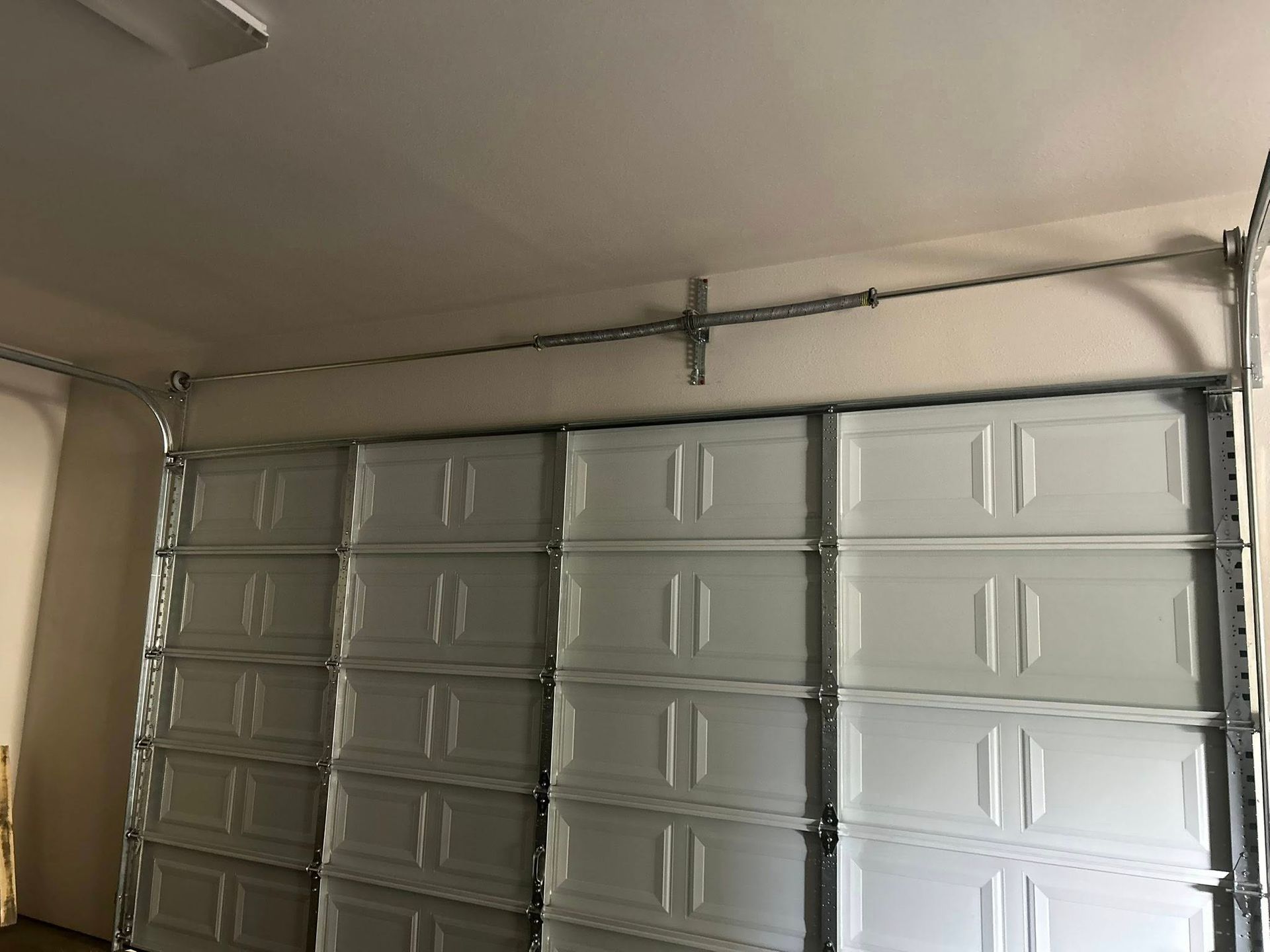 Closed gray garage door in a beige garage interior