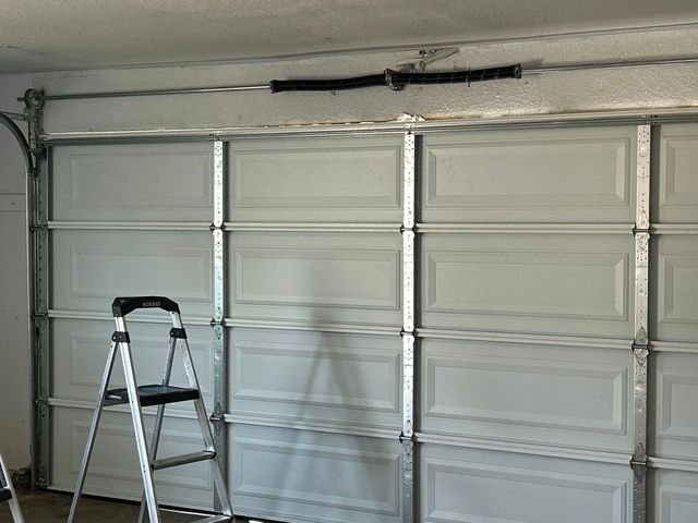 Garage interior with a white paneled door and a step ladder in front of it