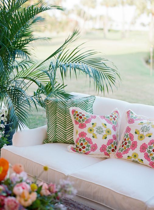 A backyard with wicker furniture and an umbrella.