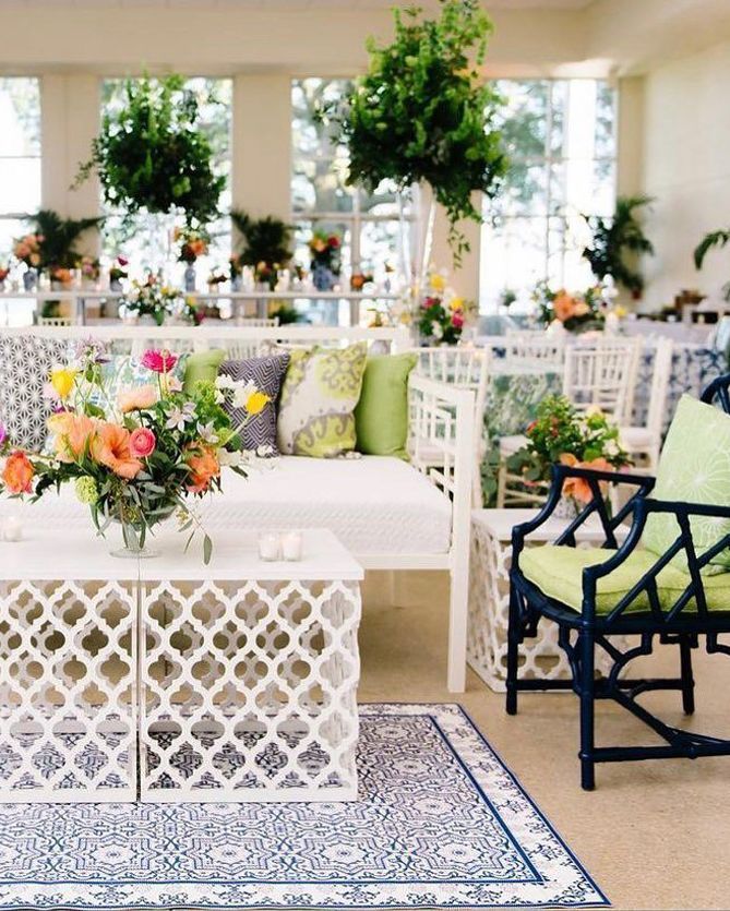 A living room with a couch and chairs and a table with flowers on it