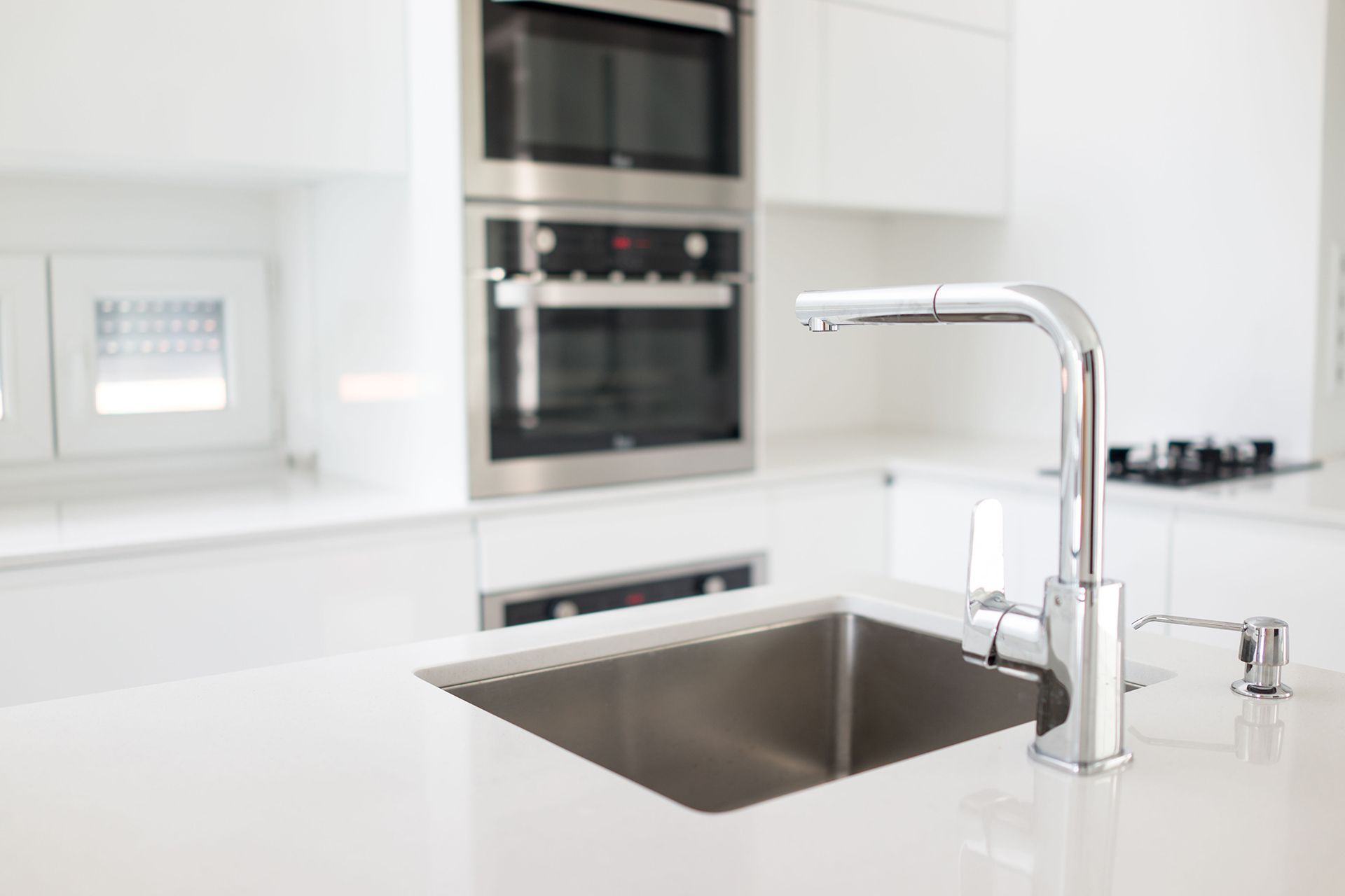 A kitchen with a stainless steel sink and a faucet