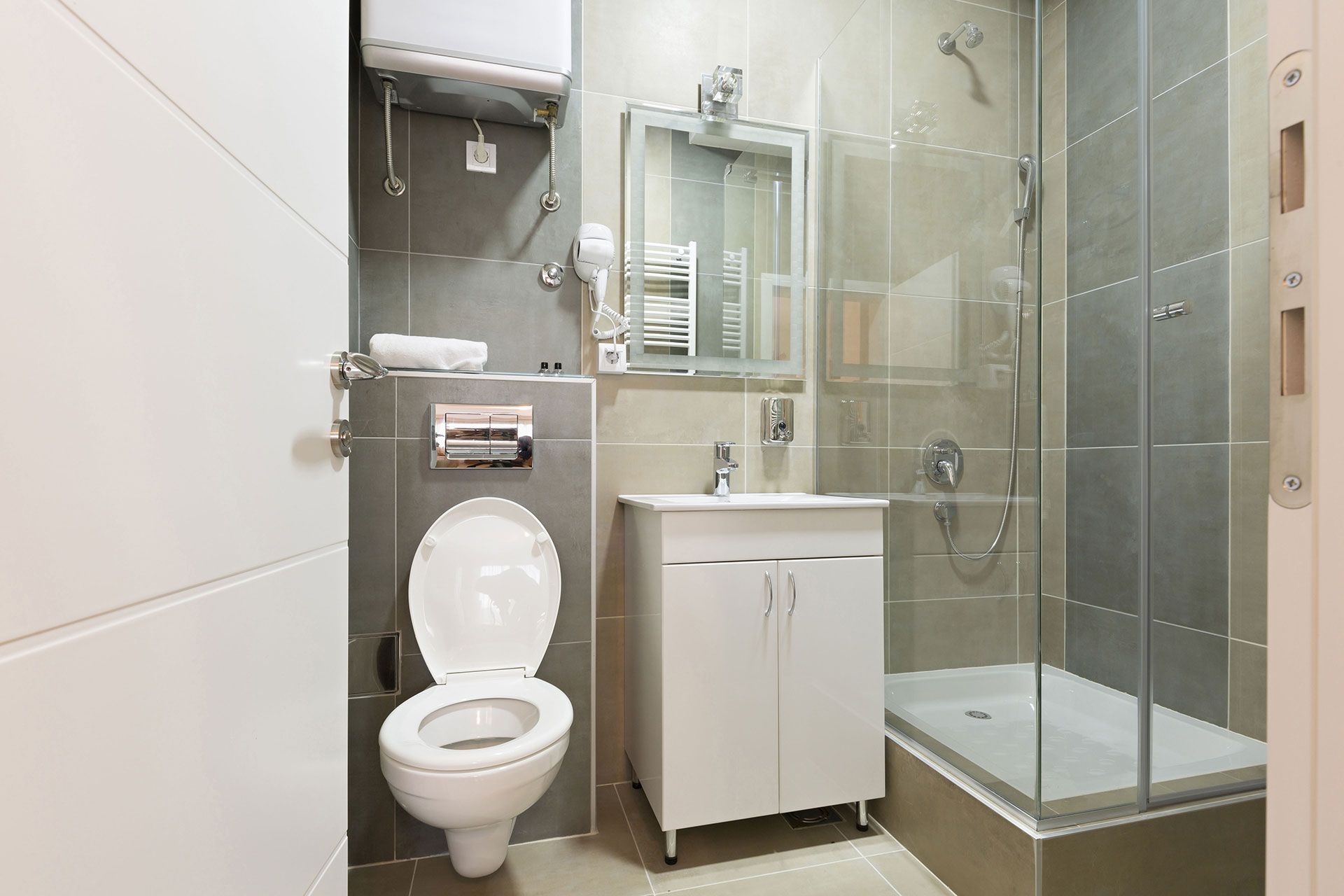 A bathroom with a toilet, sink, shower and mirror