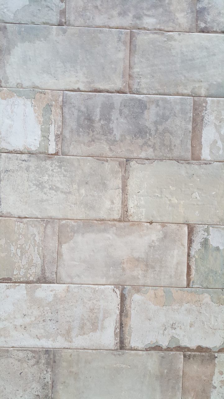 Stone brick wall, grey and off-white, with dark patches.