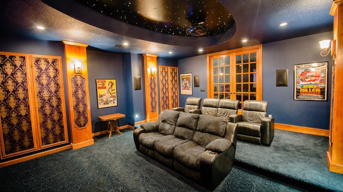 Home theater with blue walls, starry ceiling, and leather seating.