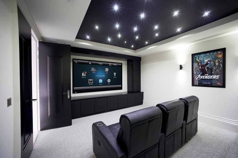 Home theater with black seating, black and white walls, starry ceiling.