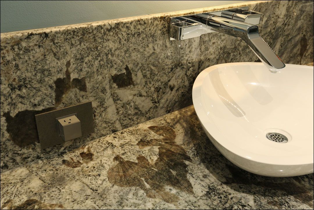 Bathroom countertop with a white, oval sink and a chrome faucet.