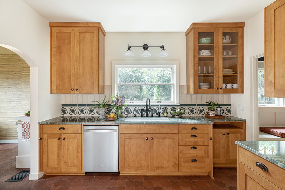 Kitchen with wooden cabinets, granite countertops, and a window above the sink.