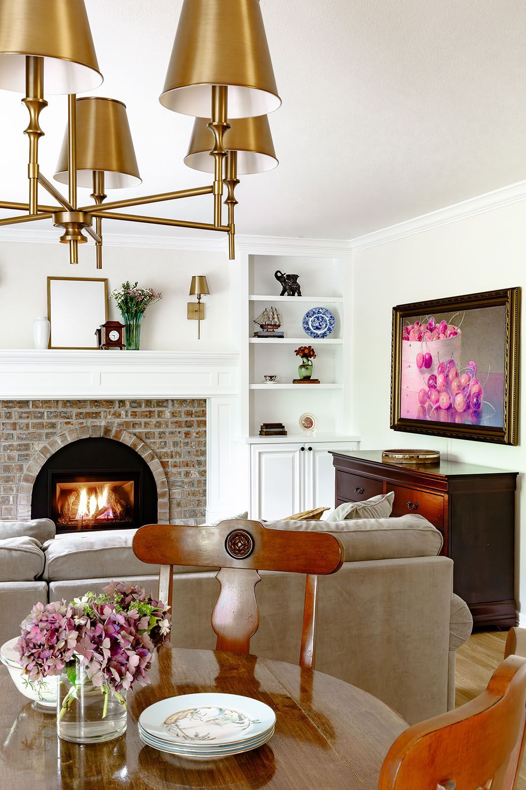 Cozy living room with fireplace, chandelier, and a round dining table