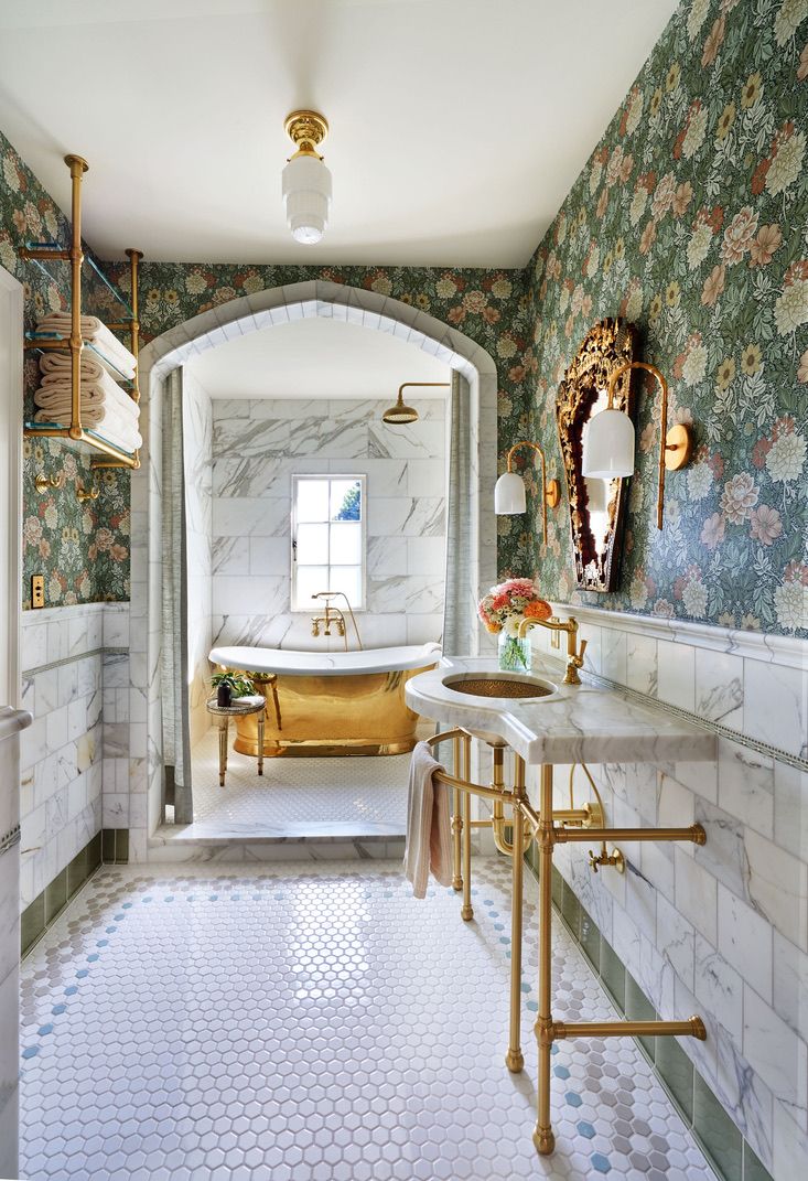 Elegant bathroom with floral wallpaper, marble and gold fixtures.