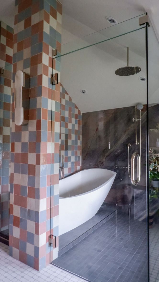 Bathroom with glass shower, soaking tub, colorful tile, and a rain shower head.