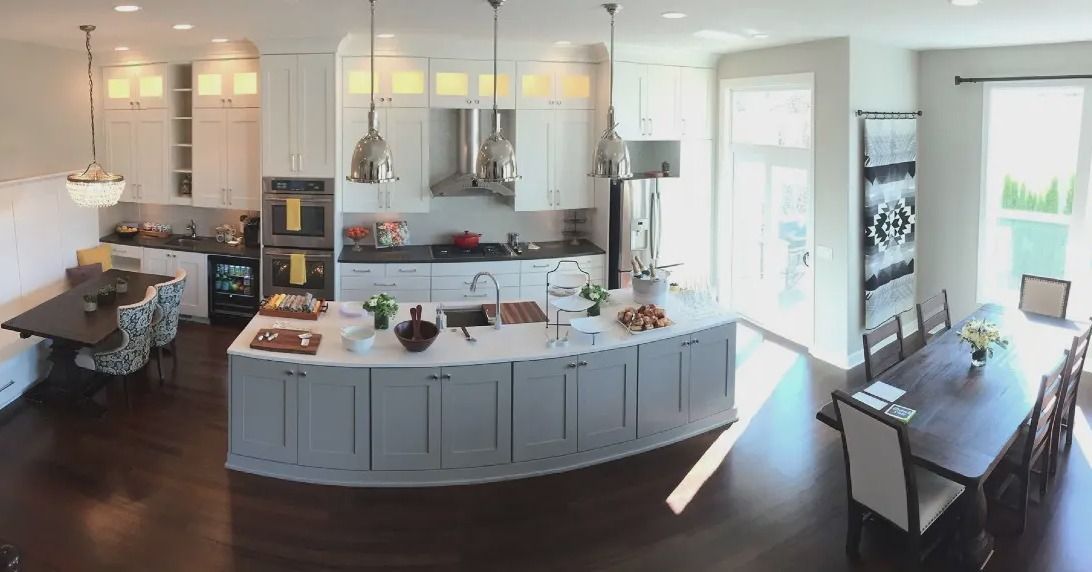 Spacious kitchen with island, cabinets, appliances, dining table, and natural light.