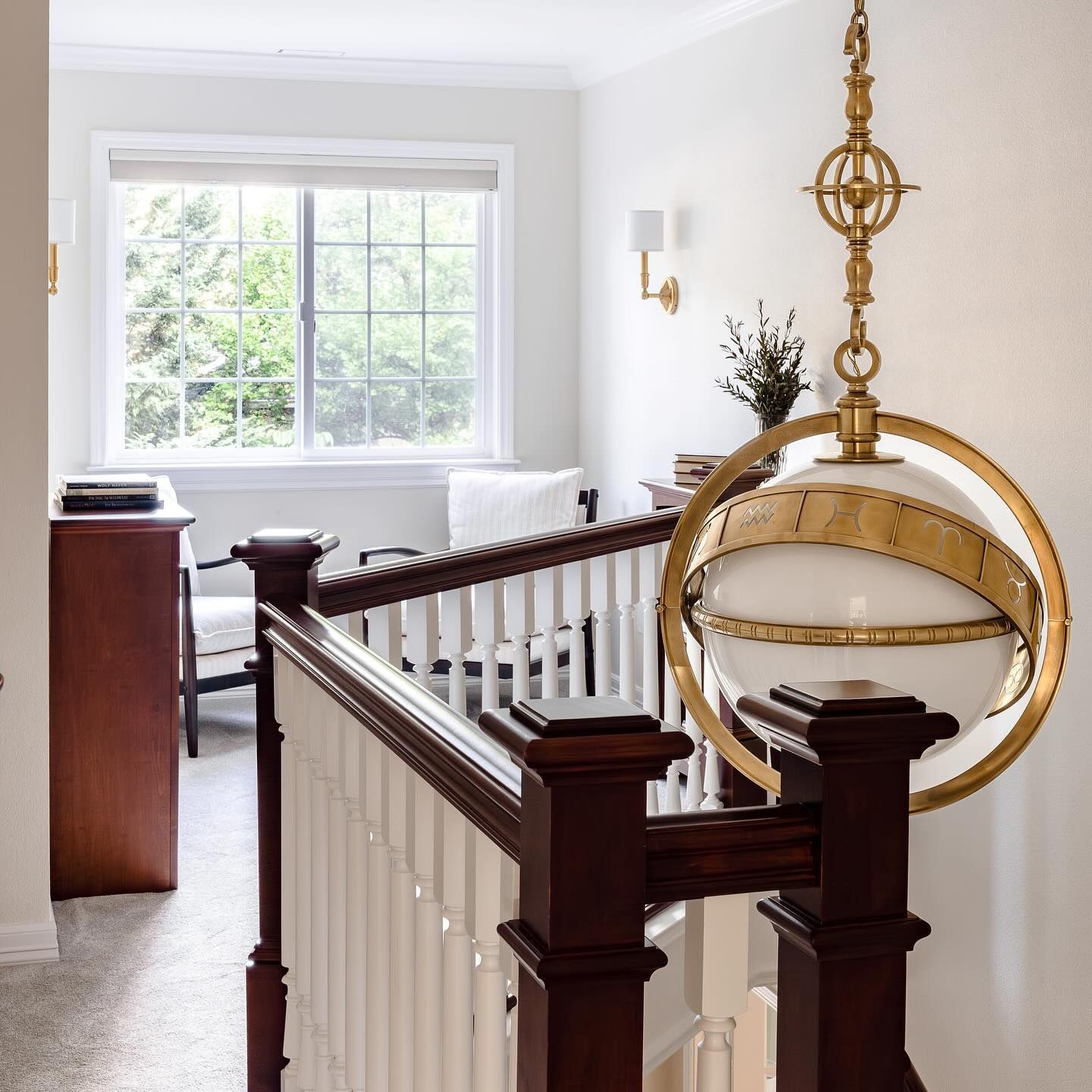 Staircase landing with a pendant light and a window overlooking greenery.