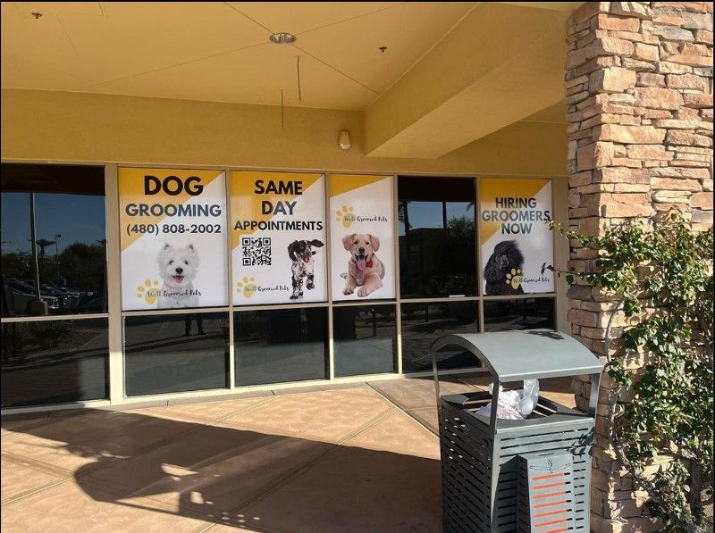 A dog grooming shop with a trash can in front of it