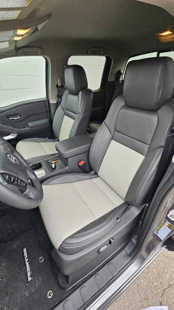 Interior of a pickup truck with gray leather front seats and center console.