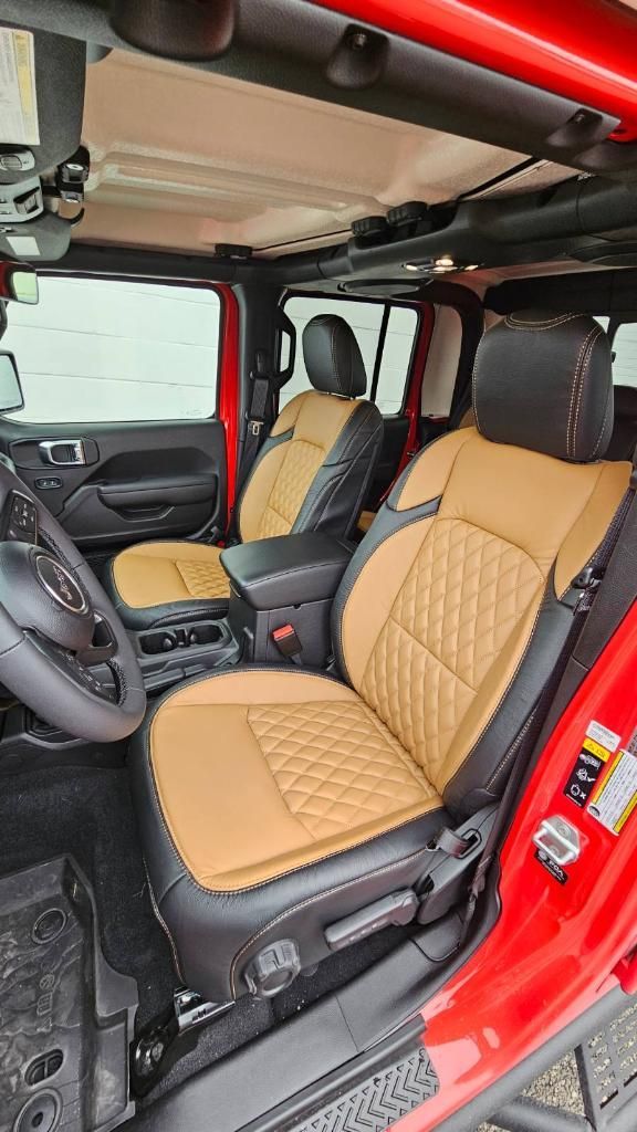 Red SUV interior with tan diamond-quilted front seats and open side door, showing a black dashboard.