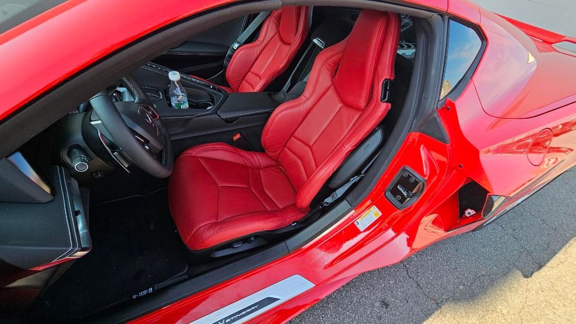 Red sports car interior with bright red leather seats and open door