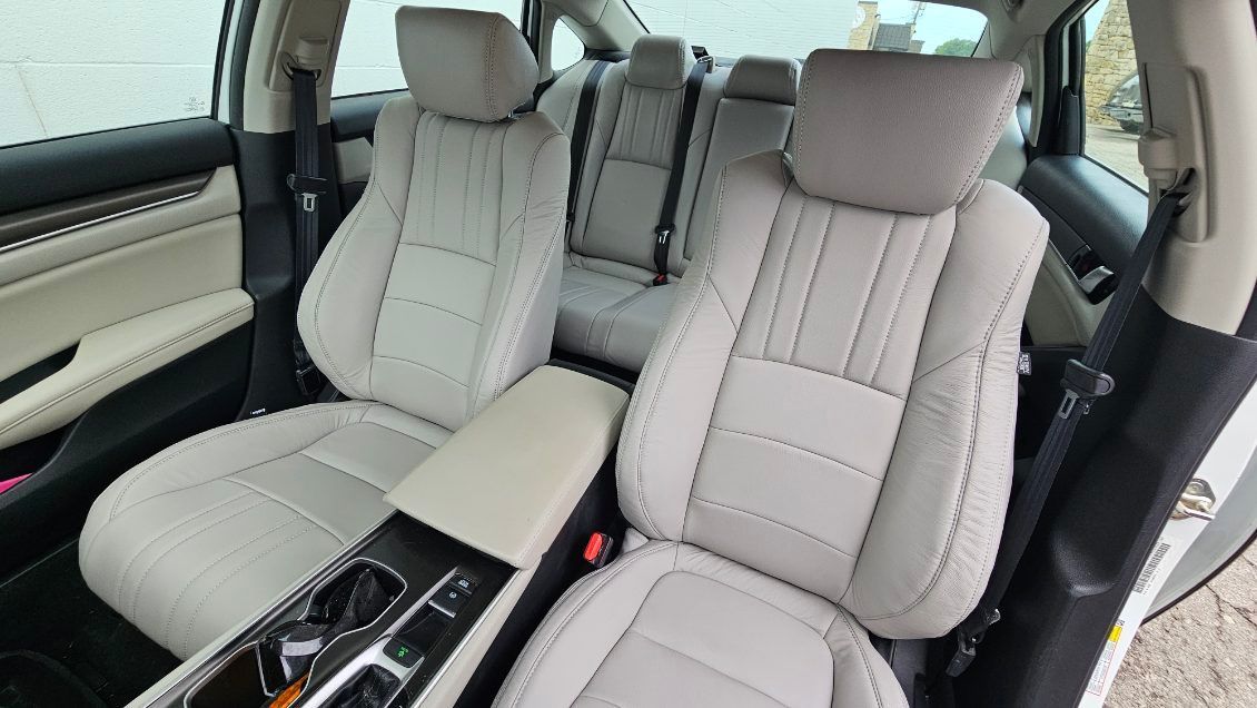 Light beige car interior with two front seats, center console, and rear seats visible