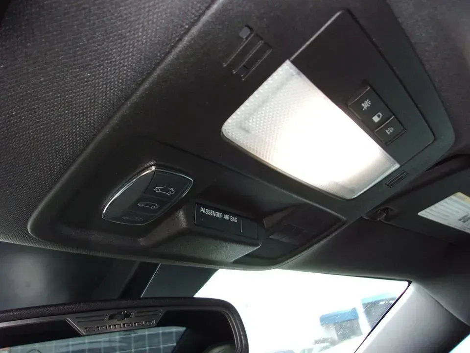 Car ceiling console with dome light, buttons, and sunroof controls above the front seats
