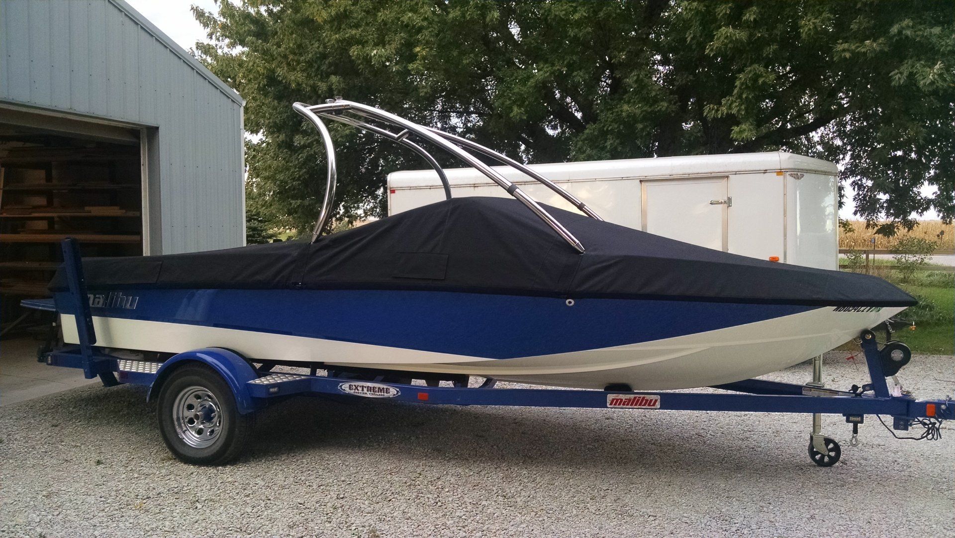 A blue and white boat with a black cover on it