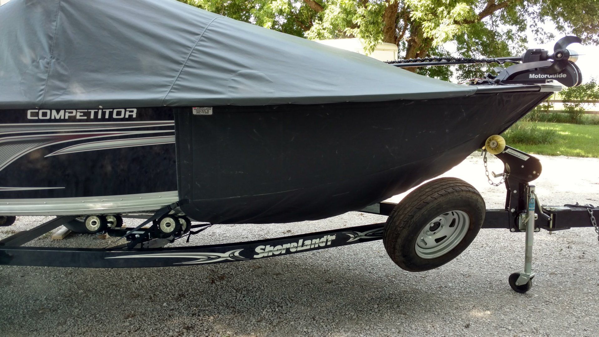 A boat is sitting on a trailer with a cover on it.