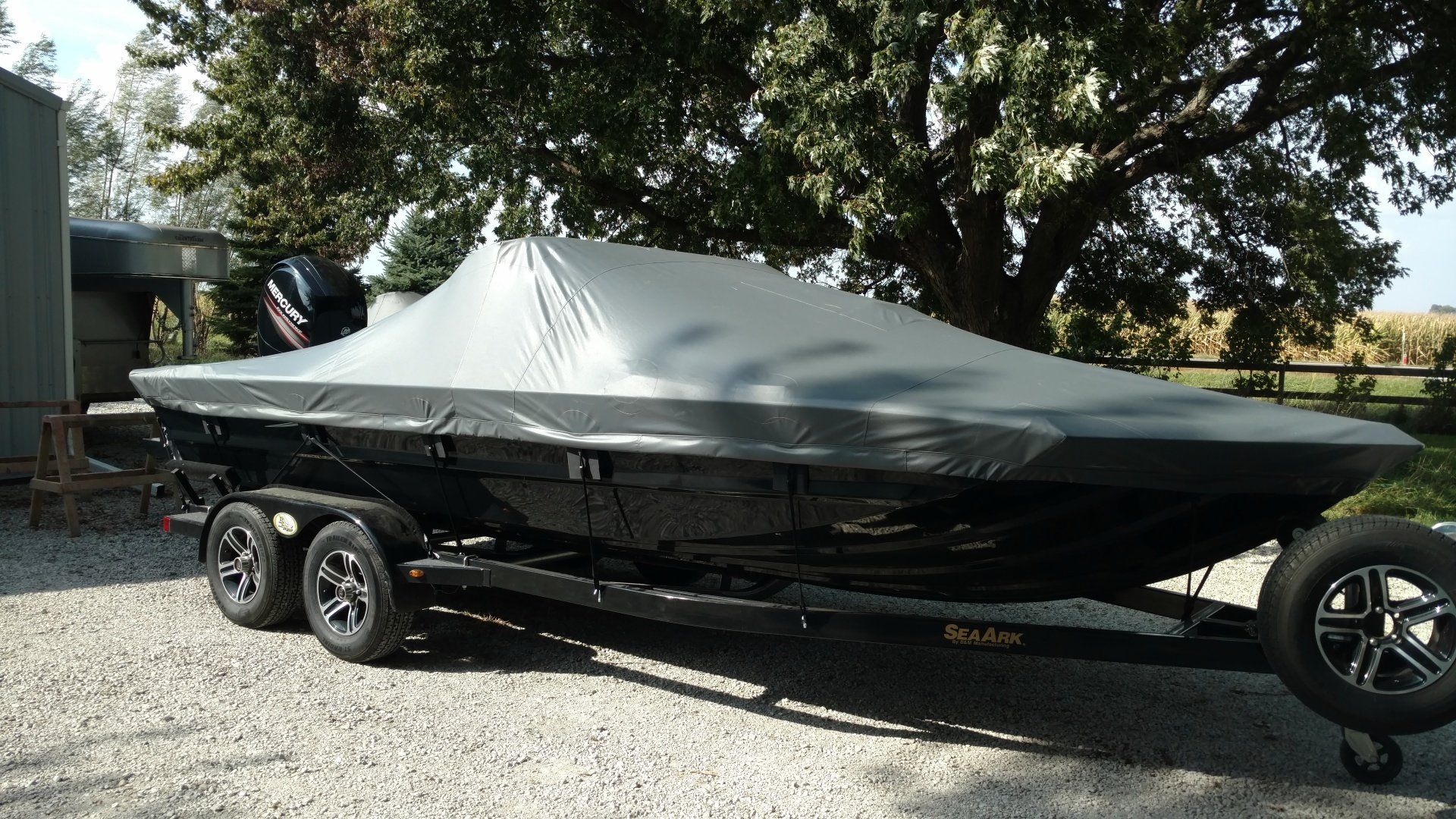 A boat on a trailer with a cover on it