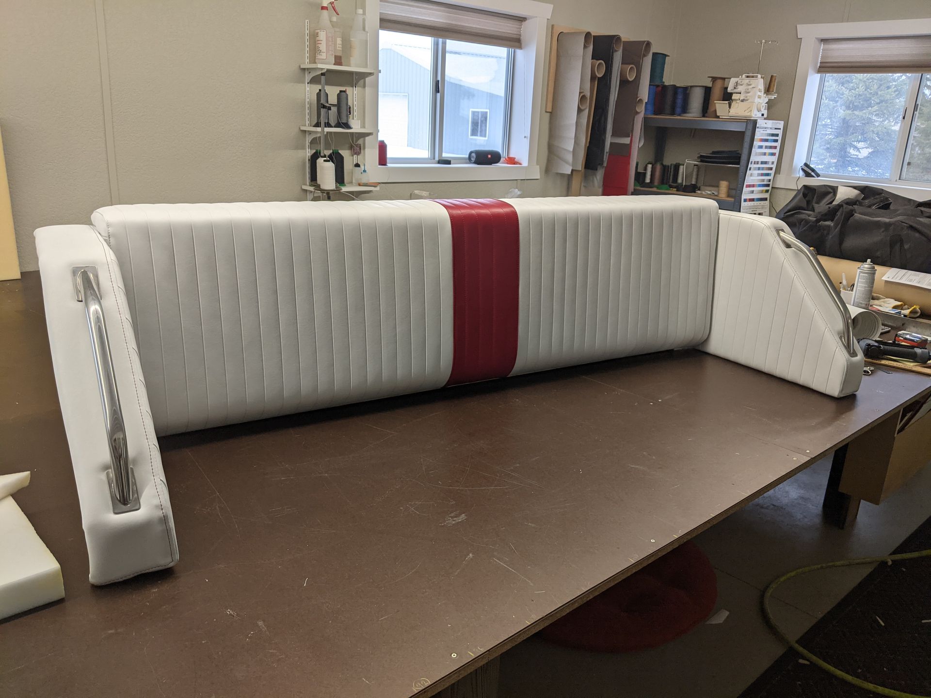 A white and red couch is sitting on a wooden table in a room.