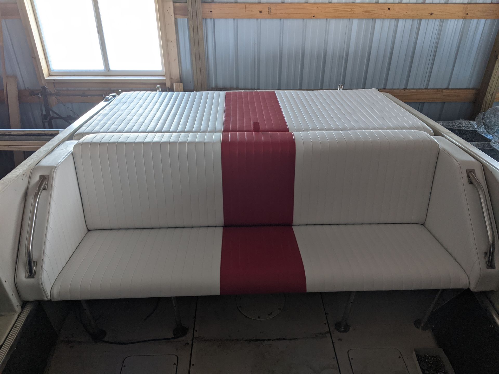 The back of a boat with a red and white striped seat cushion.