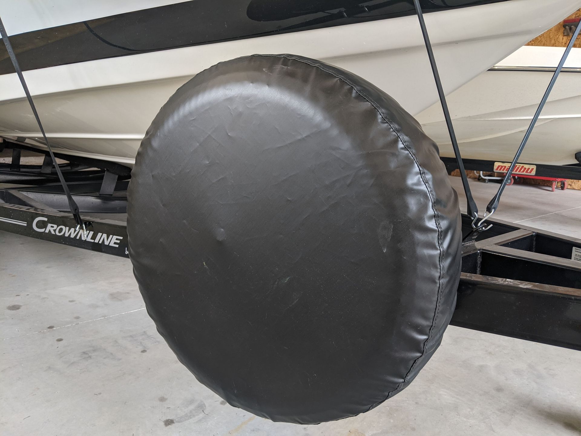 A black tire cover is attached to a boat trailer.