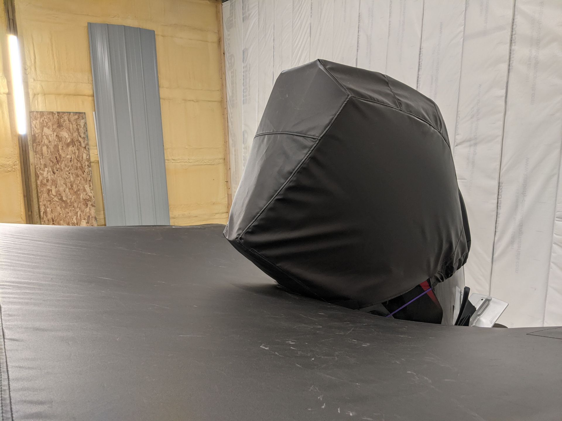 A black cover is covering the engine of a boat.