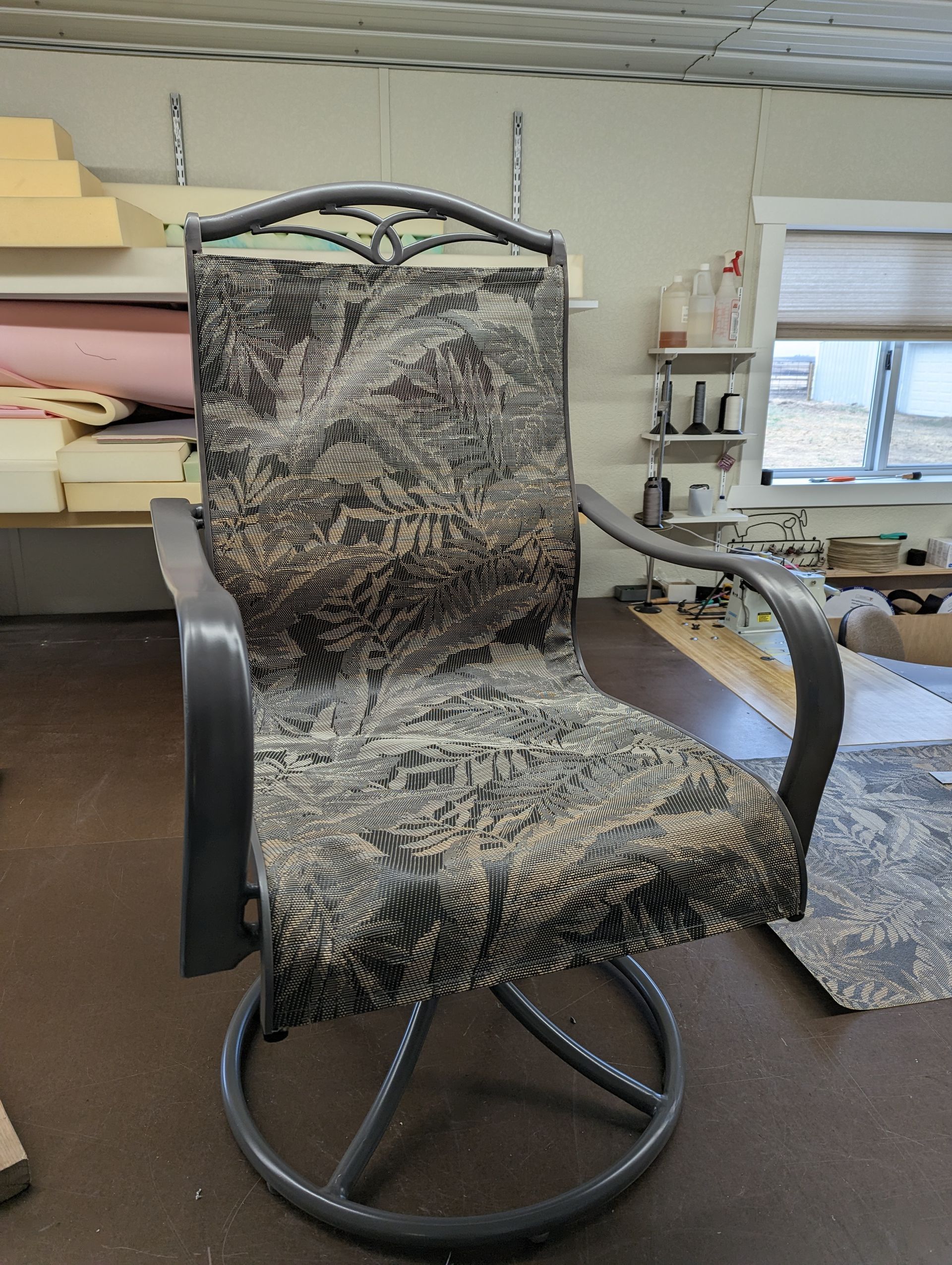 A chair with a camouflage cushion is sitting in a room.