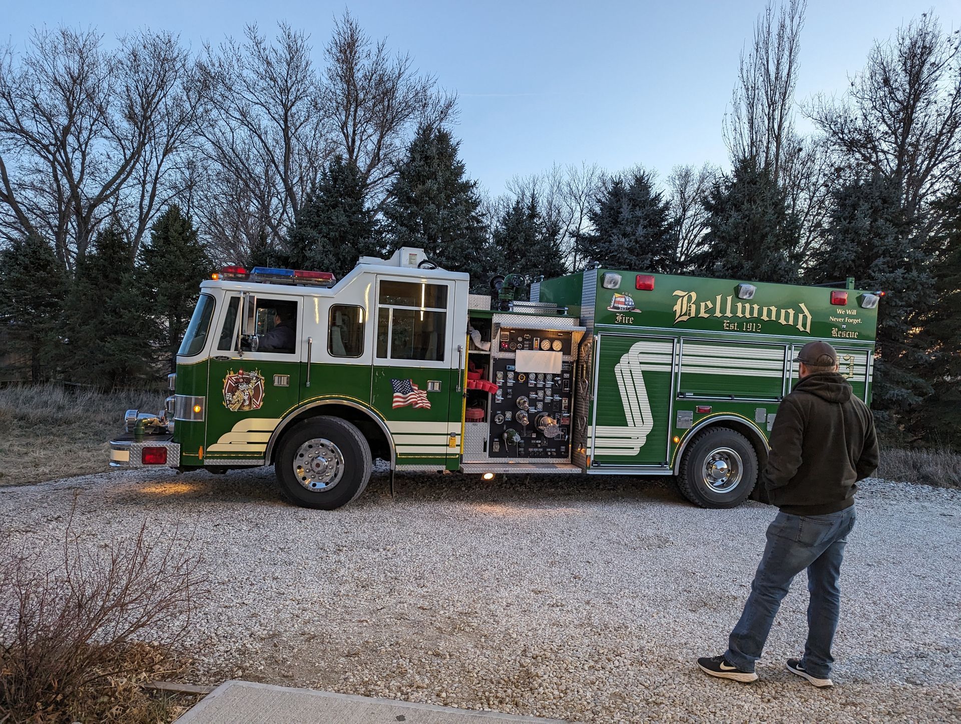 A man is standing in front of a green fire truck that says dell county