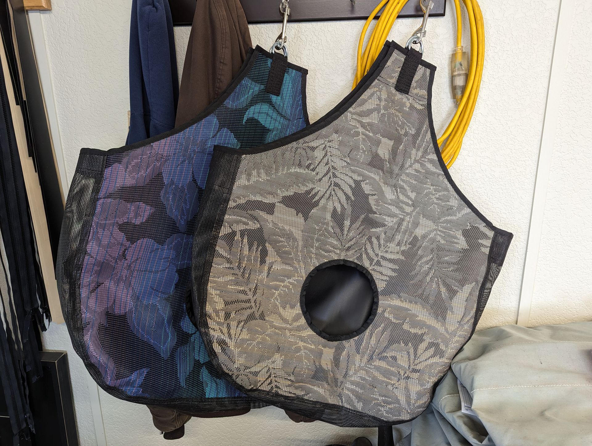 A bunch of bags are hanging on hooks on a wall