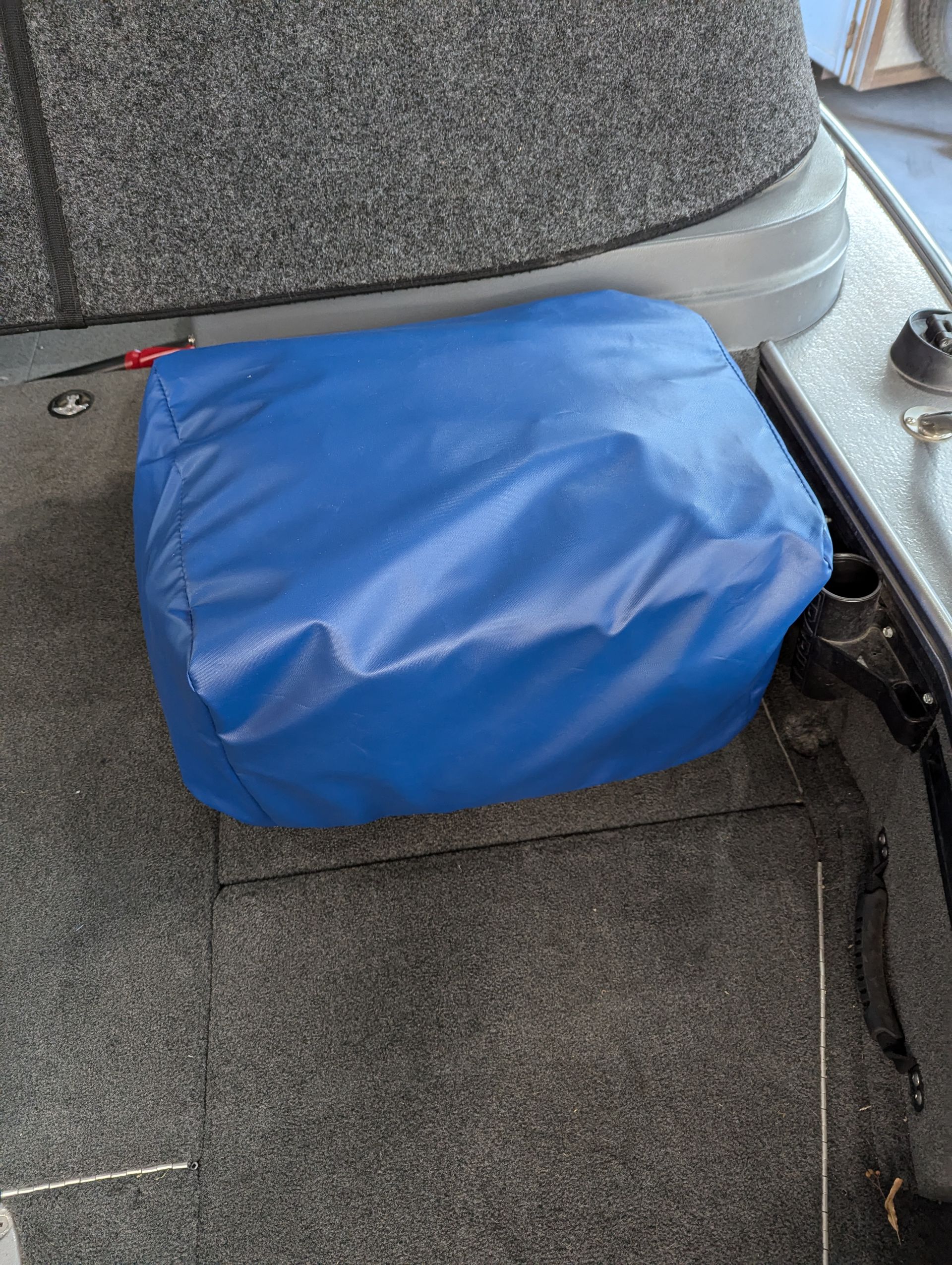 A blue bag is sitting on the floor of a boat.