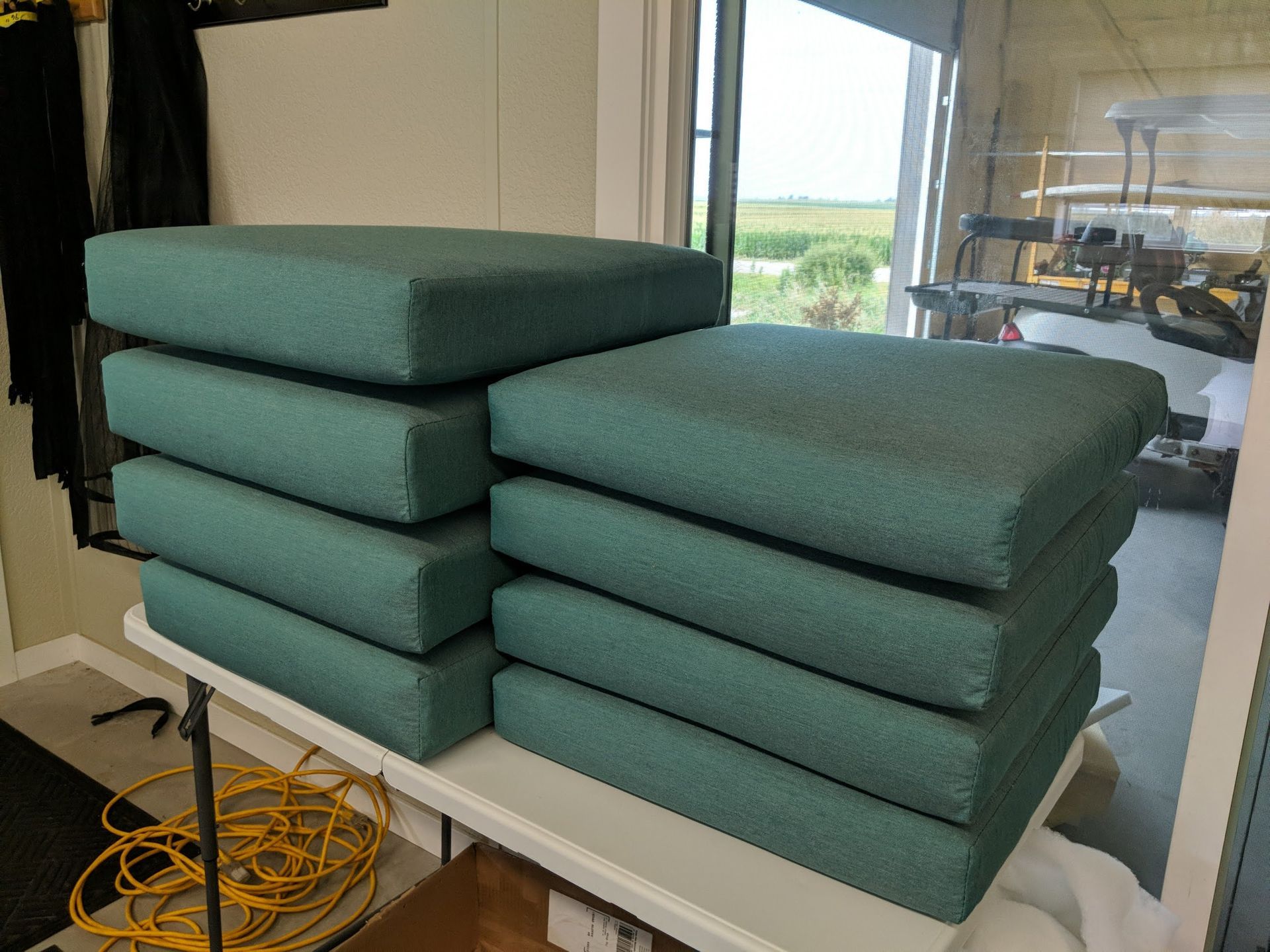 A stack of green cushions sitting on top of each other on a table.