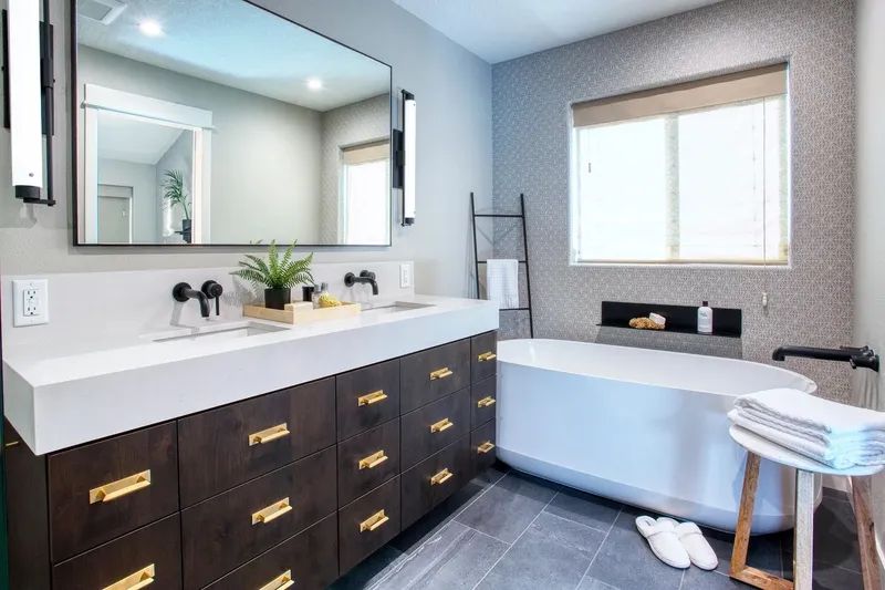 Modern bathroom with a double vanity, soaking tub, and neutral color scheme.