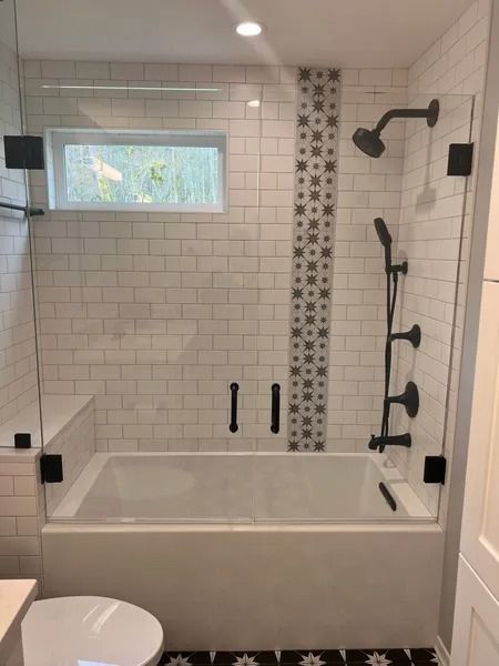 Modern bathroom with white subway tile, a bathtub, and a glass shower door.