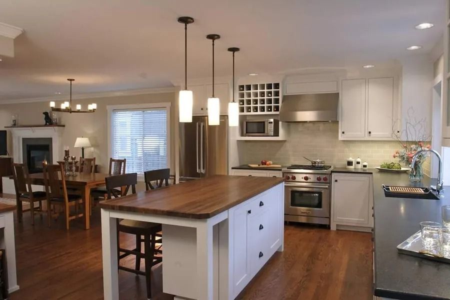 Kitchen with white cabinets, wood island, and stainless steel appliances.