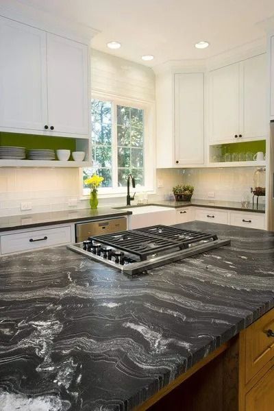 Kitchen with white cabinets, dark marbled countertop, and gas stovetop.
