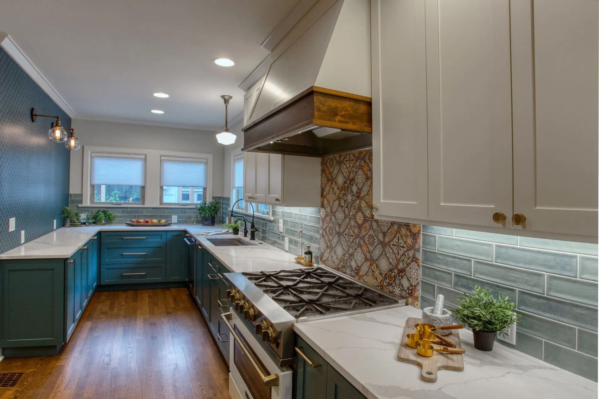 Kitchen with teal cabinetry, white countertops, and a stainless steel range hood.