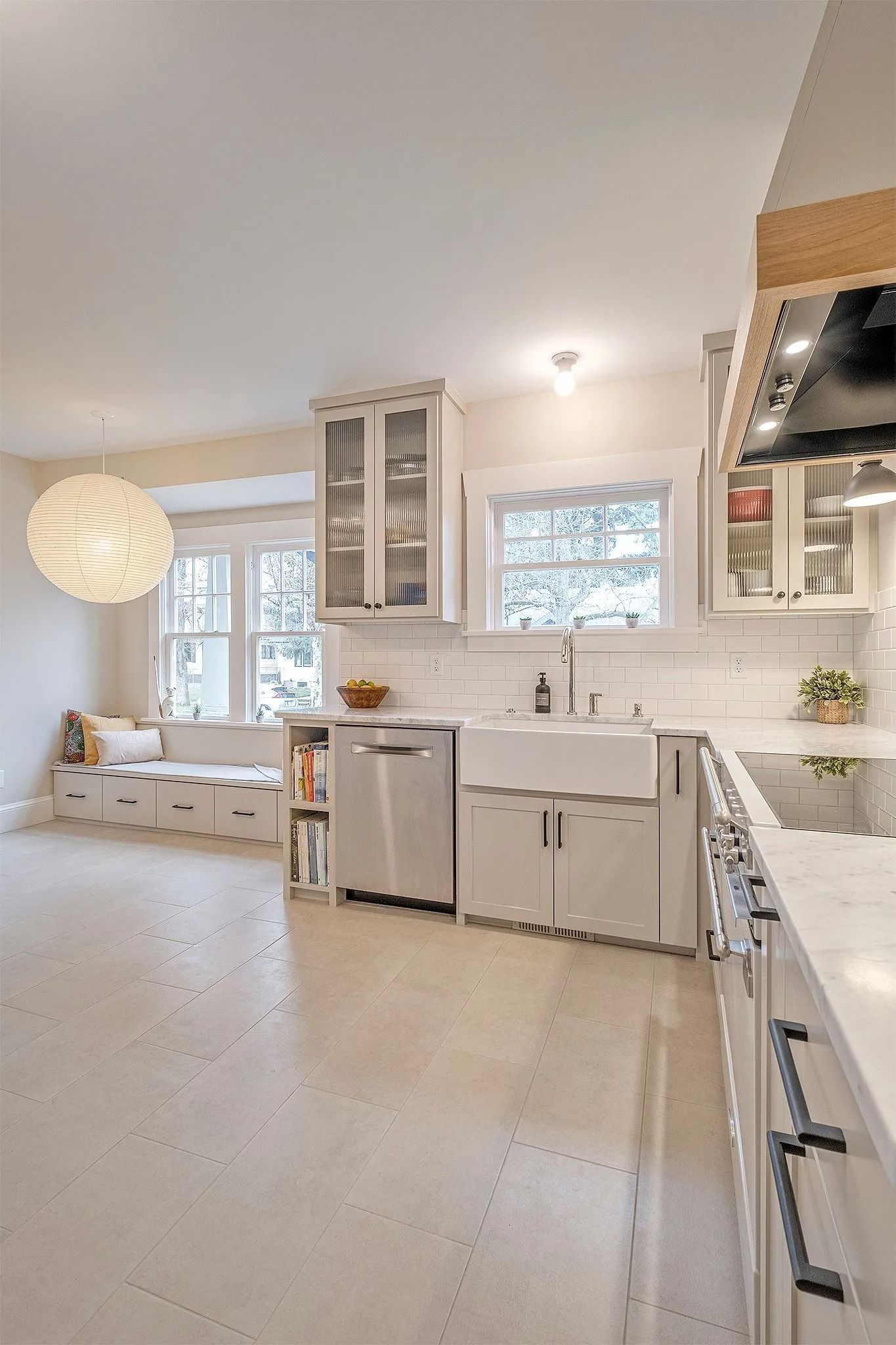 Bright, modern kitchen with white cabinetry, stainless steel appliances, and a window seat.