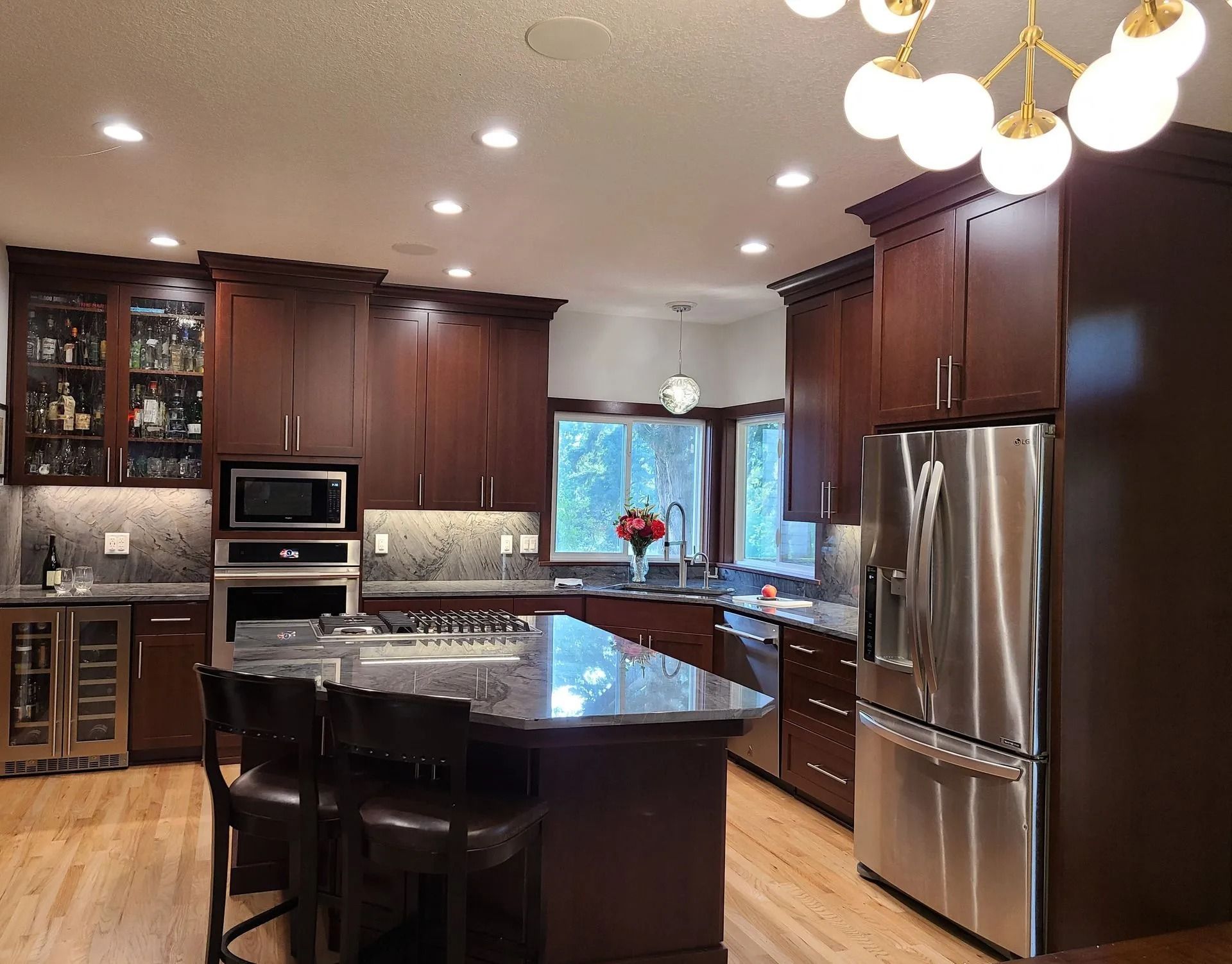 Dark wood kitchen with stainless steel appliances, granite countertops, and an island.