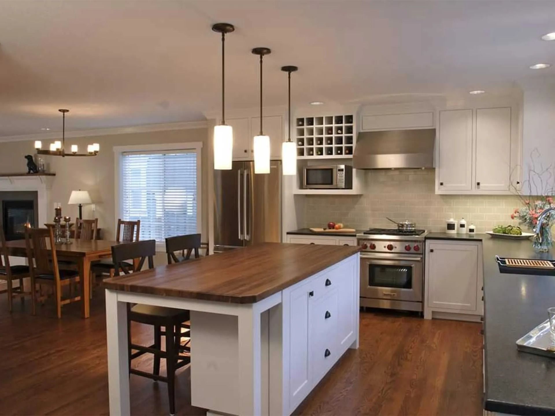 Kitchen with white cabinets, wood island, and stainless steel appliances.