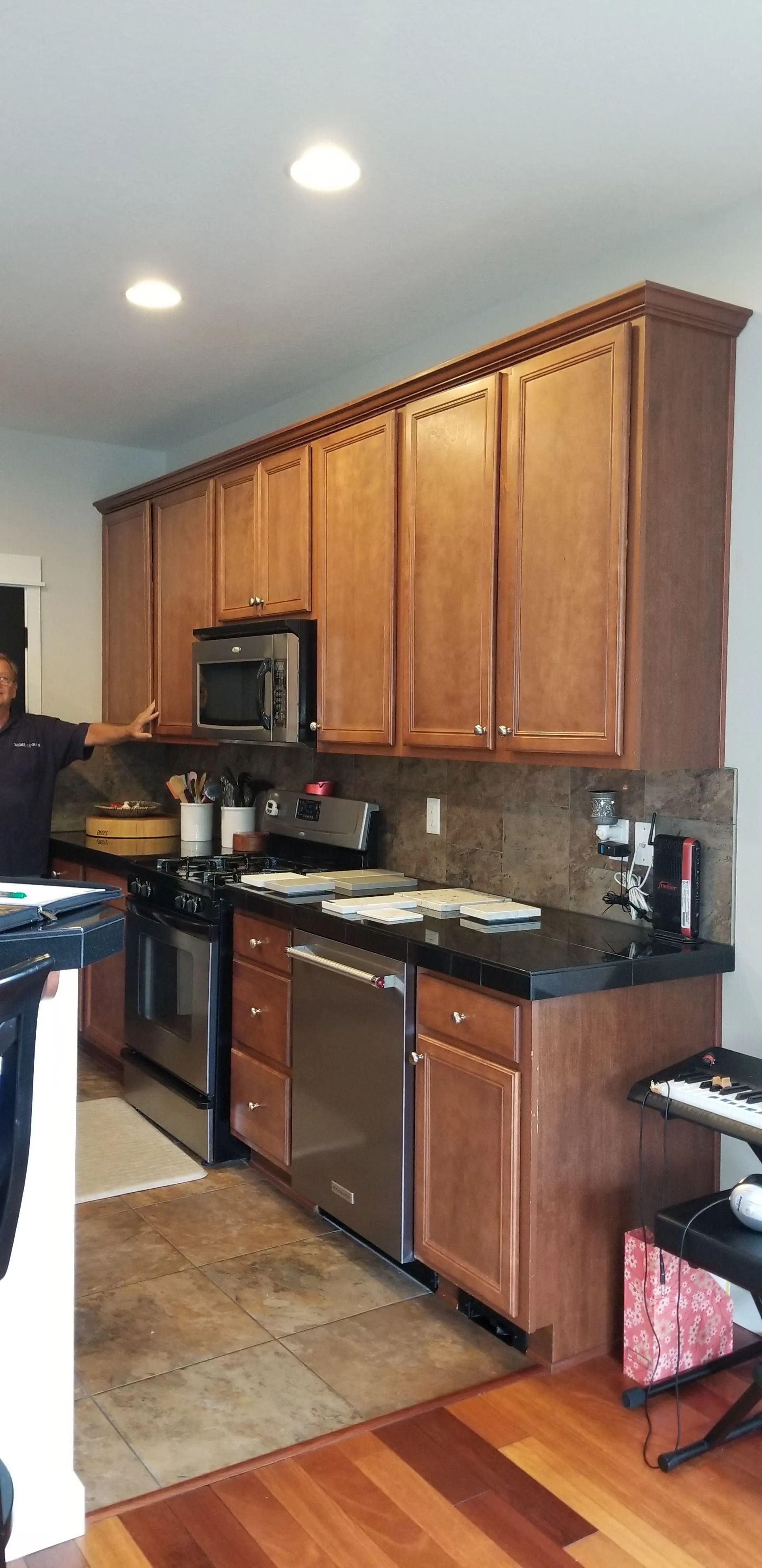 Kitchen with wood cabinets, stainless steel appliances, and black countertops.
