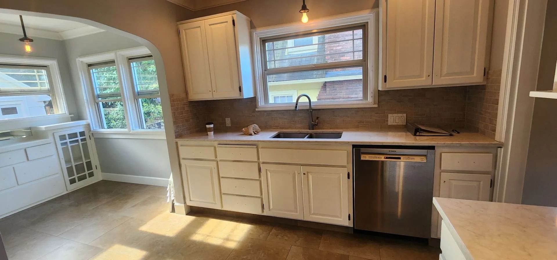 Kitchen with white cabinets, stainless steel appliances, and a window over the sink.