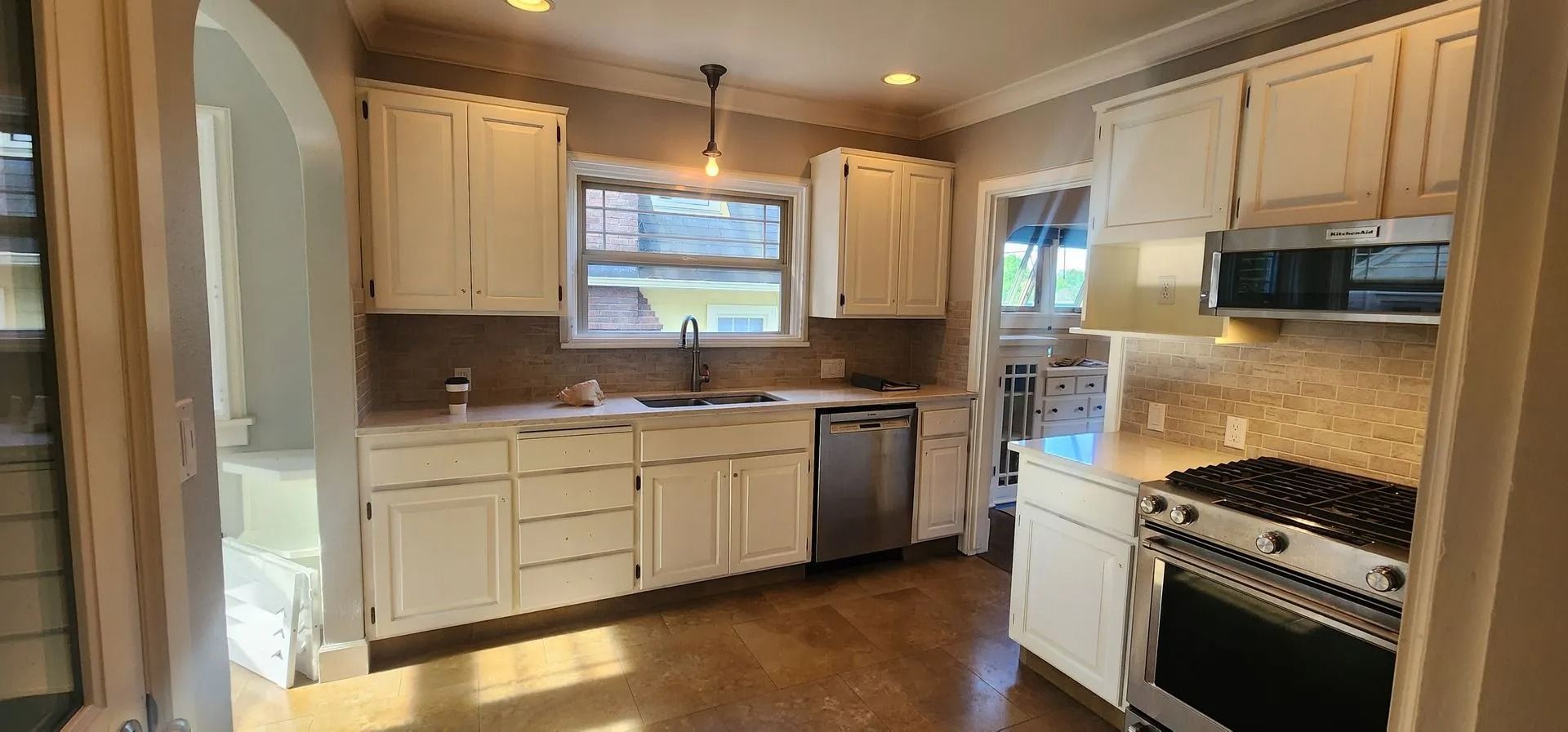 Kitchen with white cabinets, stainless steel appliances, and wood floors.