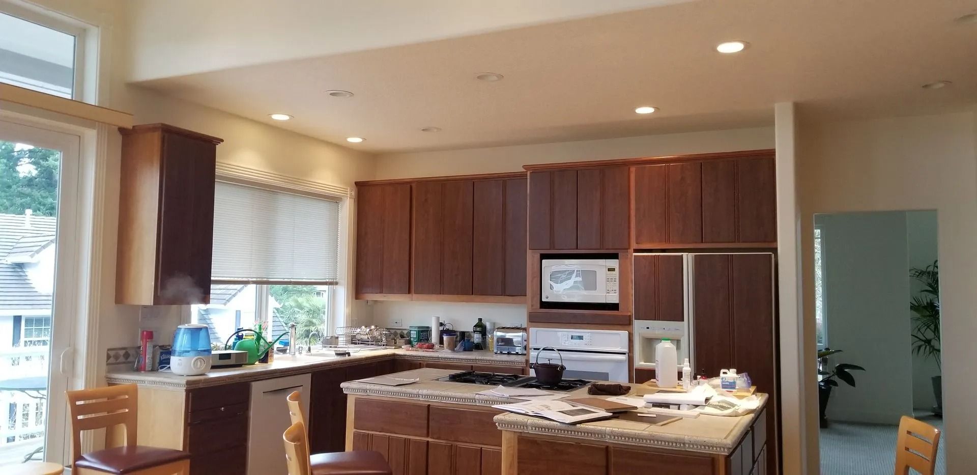 Kitchen with brown cabinets, island, and appliances. A window and doorway are also present.