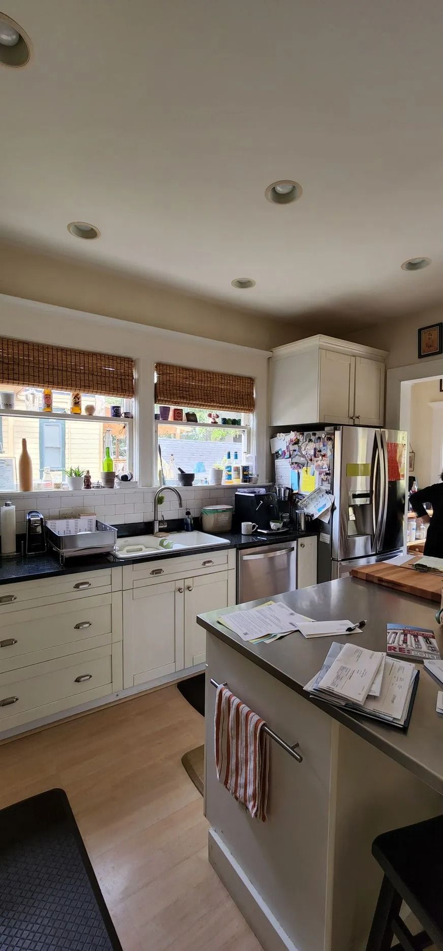 Kitchen with cabinets, stainless steel appliances, and a central island. Sunlight streams through the windows.