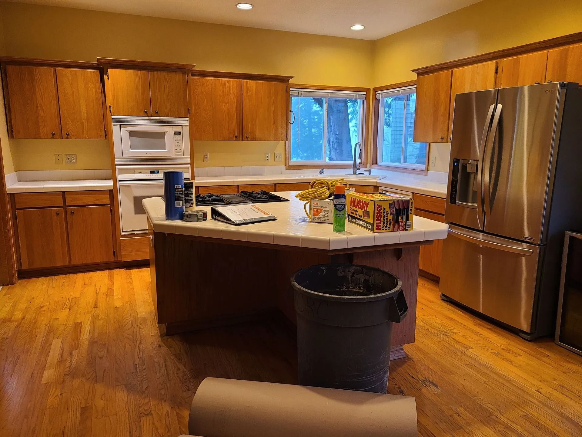Kitchen with wood cabinets, white countertops, stainless steel appliances, and an island.