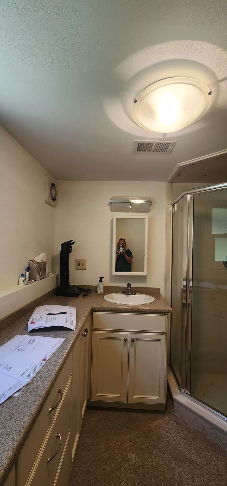 Bathroom with sink, mirror, shower, and ceiling light.
